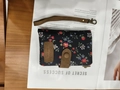 Women's floral tri-fold wallet in black fabric with wristlet strap and snap closure - Handheld Black Floral Pattern