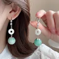 Dettaglio di orecchini d'argento con pietra occhio di gatto, zirconi e perle verdi - Fibbia Ping'an Verde Smeraldo in Stile Cinese (23#)
