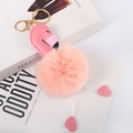 Detailed close-up of pink flamingo fur pompom keychain with golden metal clasp on books - Korean Pink - Gold Lobster Clasp