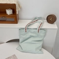 Detail of floral embroidery on the handle of a green canvas tote bag for commute - Mint Green