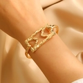 Detail shot of hammered gold cuff bracelet with geometric cutouts on champagne silk - Gold Geometric Hollow (8997)