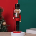 Classic wooden nutcracker soldier with red green uniform on a white festive display stand - Flag