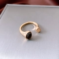 Vue macro d'une bague plaquée or 18 carats avec pierre œil de tigre et bille dorée - Doré