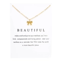 Elegante collar con colgante de lazo dorado en tarjeta blanca con mensaje inspirador - Tarjeta Blanca Cadena Dorada