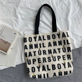 Detail of canvas tote bag featuring typography print and yellow bunny cartoon design - Boy Beige Bag