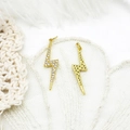 Detail of 18K gold-plated lightning pendants with crystals on lace and feather backdrop - Large Lightning