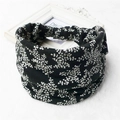 Close-up of black floral print elastic wide headband on white faux fur background - 8-Black White Flower