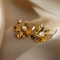 Macro detail of gold plated flower earrings with heart zircon and pearl on silk fabric - Irregular Flower Pearl