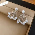 Detalle de pendientes vintage de perlas con borlas de cuentas plateadas sobre cuero - Perno de plata-Blanco