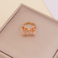Detalle de anillo de mariposa dorado con piedras rosas y naranjas sobre estuche - Melocotón