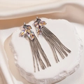 Detail von bunten Blatt-Ohrringen mit silbernen Quasten auf cremefarbener Seide - Silber (Silver Earring Post)