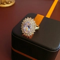 Anillo bañado en oro con gran circón ovalado y doble halo sobre un estuche negro - Estilo Dorado Chapado en Oro Real / Dorado