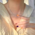 Elegant thin silver sparkling twisted titanium necklace worn on neck with sunlight glow - Necklace / Steel