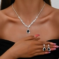 Elegant jewelry set with black teardrop gemstones and silver chain on model - 695 Black Necklace + Stud Earrings Set