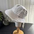 Detail van beige vissershoedje met brede rand stiksels en hartvormig metalen decor - M (56-58cm) / Beige