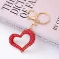 Sparkling red crystal heart keychain with golden metal clasp on a pink fashion book - Hollow Red Full Rhinestone Heart