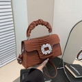 Detail of caramel brown croc-embossed handbag with luxury rhinestone buckle and pleated handle - Brown