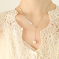 Elegant wheat spike necklace with pearls in silver finish worn on model over lace fabric - Silver Sliding Style (2 Beads)