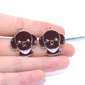 Macro shot of two brown Teddy dog enamel charms on a finger for DIY jewelry crafting - Teddy Dog