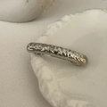 Detailed view of a silver metal hair clip with hammered texture on a ceramic plate - Silver-Bar