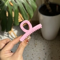 Vue détaillée d'une pince à cheveux rose robuste en plastique avec ressort métallique - Rose crème