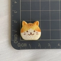 Vista macro di un ciondolo a gatto in resina di 2,5 cm con scala di riferimento - Pane di Gatto