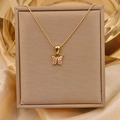Detail view of 18K gold butterfly necklace with pink gemstone on brown gift box - Gold + Pink (Bead Chain)