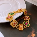 Macro detail of vintage gold bracelet with colorful enamel inlay and sparkling rhinestones - Multicolor