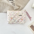Detail of floral quilted cotton pouch featuring puppy print and a pink zipper pull - Colorful Star Puppy