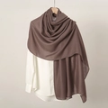 Detailed texture of brown linen scarf draped over a shirt on a minimalist background - Dark Coffee