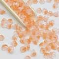 Macro shot of lily of the valley beads with orange-pink gradient on a wooden spoon - Lily of the Valley 22# Orange 7x12mm