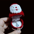 Mano sosteniendo un joyero de terciopelo de Papá Noel con un colgante de gota azul dentro - Papá Noel (Solo Caja)