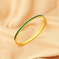 Dettaglio del bracciale in titanio placcato oro con cristalli verdi su seta color beige - Verde