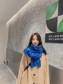 Elegant blue knitted wool scarf with fringe detail worn with a beige winter coat - Klein Blue