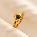 Macro shot of gold sunburst ring with black marble stone on silk fabric background - Gold-Black Marble