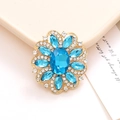 Macro shot of blue crystal flower accessory with gold base and sparkling rhinestones - Lake Blue
