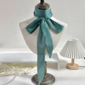 Elegant sage green satin skinny scarf tied as a bow on a white mannequin neck - 190*5cm / Aqua Green