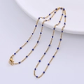 Minimalist golden O-chain necklace featuring small blue beads on a white ceramic tray - Gold - Blue Beads