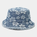 Detailed macro view of white floral embroidery and frayed edges on denim bucket hat - One Size / Light Blue
