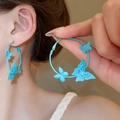 Blaue Schmetterling-Creolen mit mattem Finish an einem weiblichen Modell gezeigt - 99# Silber-Ohrstecker-Blau
