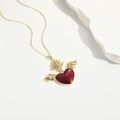 Macro detail of winged heart pendant with red enamel inlay and gold chain necklace - Burgundy Winged Heart