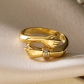 Vista macro de anillo chapado en oro 18K diseño manos con micro cristales - Estilo de Abrazo de Manos Doradas