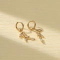 Golden titanium steel leaf earrings with clear zircon crystals on a textured background - White Marquise Pendant Style (NMSE-C242-3)