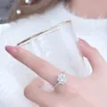 Elegant silver heart flower ring with sparkling cubic zirconia on a white knit sweater - J1 (White Gold)
