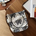 Primer plano del estampado de mariposas en el bolso de lona con detalles de la correa - Bordado de Mariposa en Fondo Beige