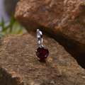 Macro shot of a red gemstone pendant set in S925 silver on a natural rock background - Natural Garnet Round Pendant Silver