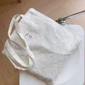 Detailaufnahme der Blumenstickerei und des Stoffetiketts auf cremeweißer Canvas-Tasche - Cremeweiß Kleine Blumenstickerei