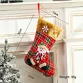 Plaid Christmas stocking with plush cuff and 3D snowman figure hanging on white fireplace - Medium Plush Snowman Style