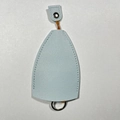 Light blue leather key cover with snap strap and metal ring on white textured surface - Solid Pink Blue