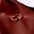 Detail eines goldenen Schaukelpferd-Rings mit roter Emaille auf roter Seide - Ring - Gold - Rot